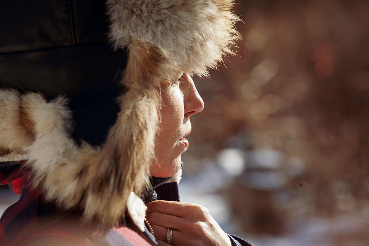 Woman wearing warm clothing standing outdoors. (Photo: Adobe Stock │ #298319443 - Cavan for Adobe)