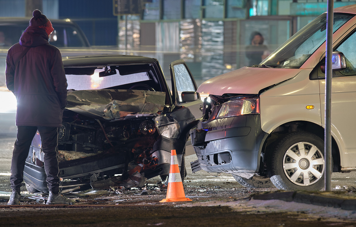 Cars crashed heavily in road accident after collision and silhouette of people on city street at night. (Photo: Adobe Stock │ #486569664 - bilanol)