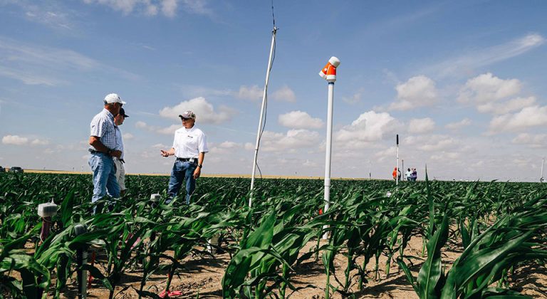 Western Kansas farmers Russ Martin and Jay Ostmeyer (left) talk with K-State irrigation engineer Jonathan Auguilar about the use of soil moisture sensors, during the recently completed TAPS competition. (K-State Research and Extension)