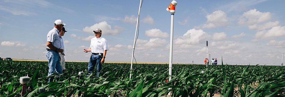 Western Kansas farmers Russ Martin and Jay Ostmeyer (left) talk with K-State irrigation engineer Jonathan Auguilar about the use of soil moisture sensors, during the recently completed TAPS competition. (K-State Research and Extension)