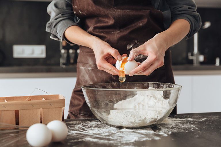 A young woman cooking the dough. (Adobe Stock │ #137054202 - Drobot Dean)