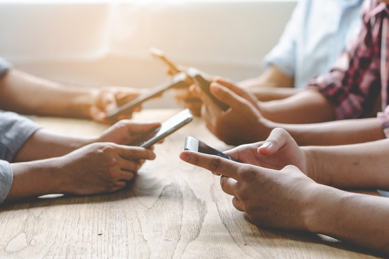 Group of friends playing app games in mobile phone and online together. (Adobe Stock │ #225254264 - Pormezz)