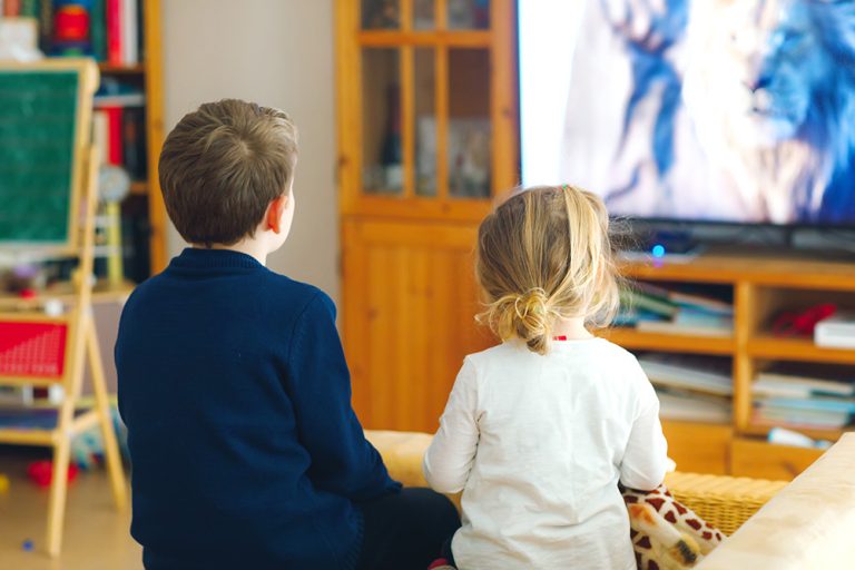 Cute little toddler girl and school kid boy watching animal movie or movie on tv. (Adobe Stock │ #334432582 - Irina Schmidt)