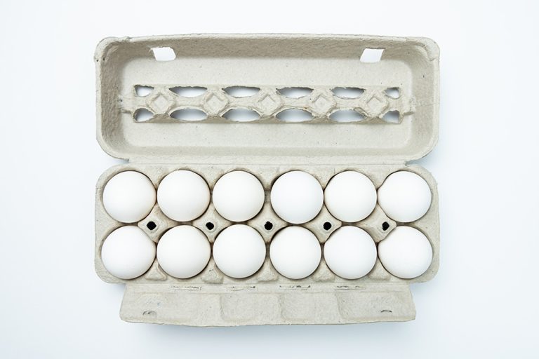 One dozen white eggs in a carton package. (Adobe Stock │ #348670594 - Kenishirotie)