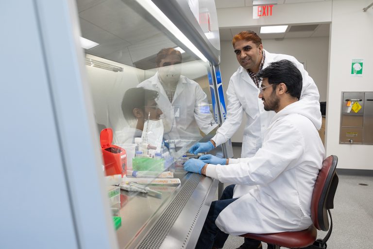 Researchers led by (standing) Sunil Mor, assistant professor at South Dakota State University, are developing a diagnostic test for avian metapneumovirus types A and B, as well as a vaccine. (Courtesy photo.)