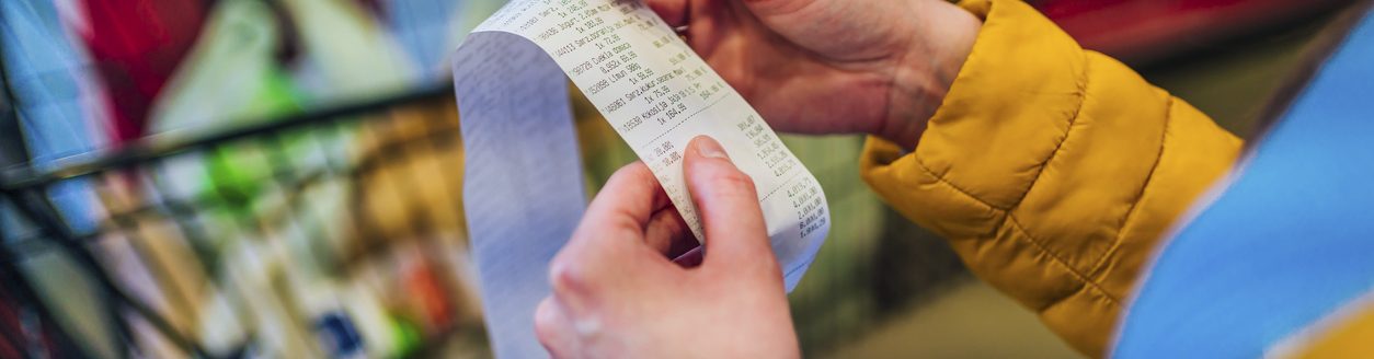 Woman looking receipt from a supermarket. (iStock │ #1386010216 - LordHenriVoton)