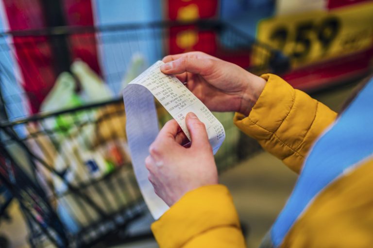 Woman looking receipt from a supermarket. (iStock │ #1386010216 - LordHenriVoton)