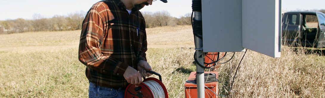 Aaron Young, survey geologist with the Conservation and Survey Division, Nebraska Geological Survey at the School of Natural Resources, University of Nebraska-Lincoln, performs maintenance on water wells. (IANR Conservation and Survey Division)