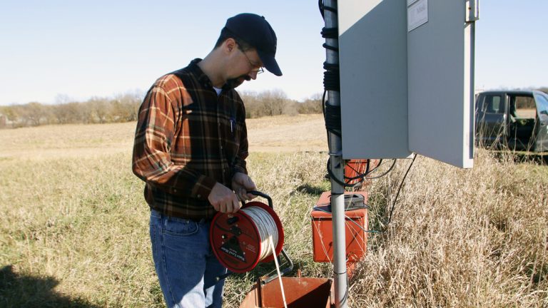 Aaron Young, survey geologist with the Conservation and Survey Division, Nebraska Geological Survey at the School of Natural Resources, University of Nebraska-Lincoln, performs maintenance on water wells. (IANR Conservation and Survey Division)
