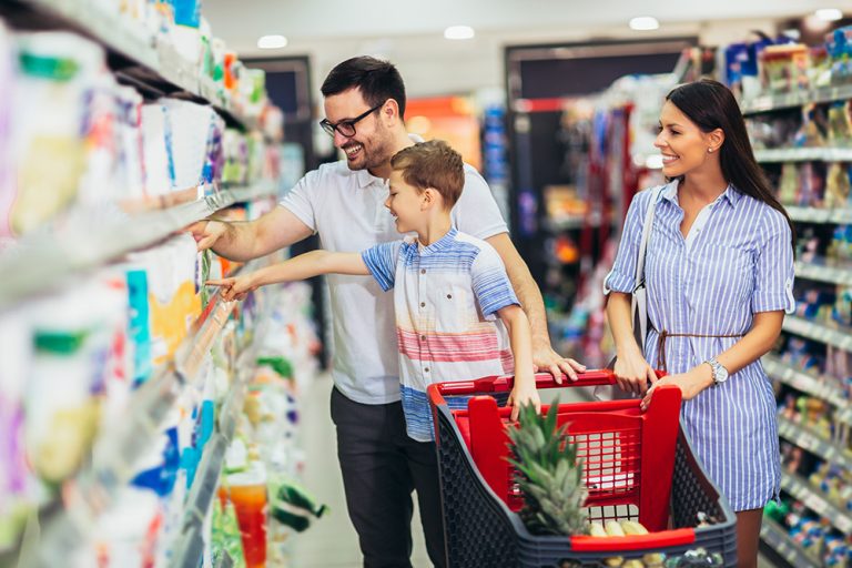 Happy family with child and shopping cart buying food at grocery store or supermarket. (Adobe Stock │ #345313767 - Mediteraneo)