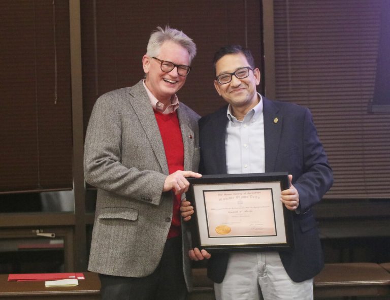 Panhandle Research Extension and Education Director John Westra, left, and Bijesh Maharjan, Nebraska Extension Specialist, with his award at the annual Gamma Sigma Delta banquet. (Eric Buck)