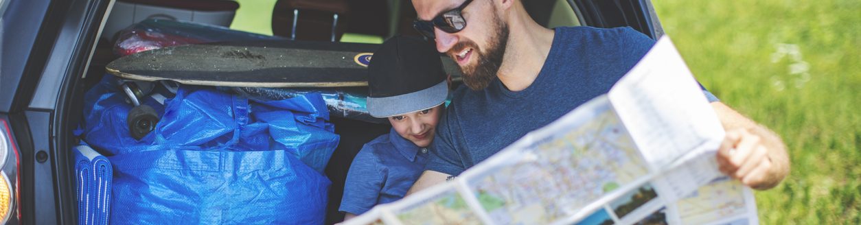 Father and son looking at map. (iStock │ #1158057935 - JulPo)