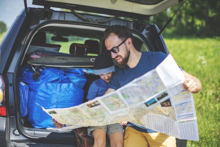 Father and son looking at map. (iStock │ #1158057935 - JulPo)