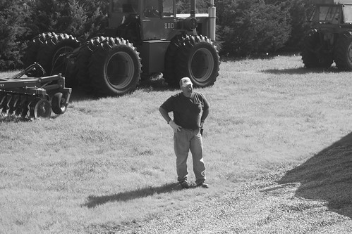 Dad watches as Brandon drives the combine up on to the trailer.