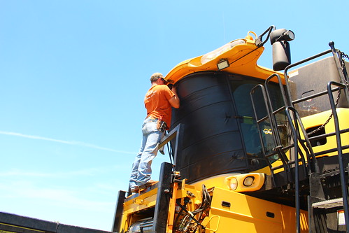 Brandon strapping the window cover on the other combine.