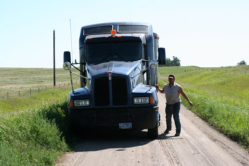 Damon jumps out of the truck to await the field to get open enough to park in.