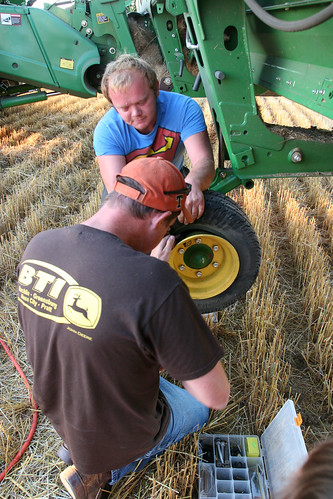 Johan applys pressure to the tire while Leon finds the tire valve stem.