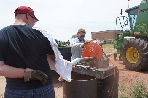 Vincent cuts the scrap iron down to size while August holds it for him