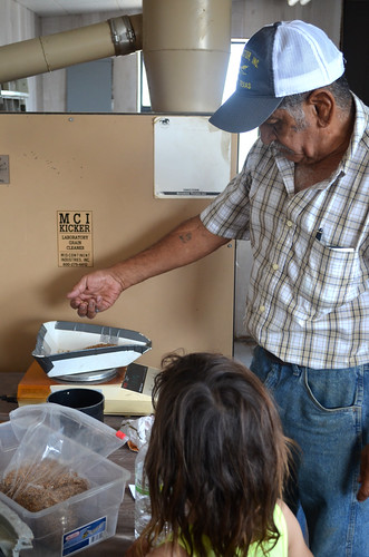 Kaidence looks on as the elevator employee prepares a sample for the moisture test