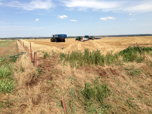 The final stopping point of the truck with offloaded grain cart and farmers helping hands and tractor