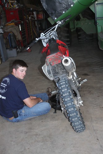 Brandon changing oil on his dirt bike. He missed all his toys.
