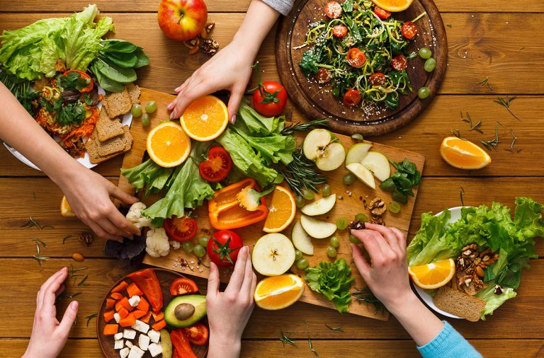 Dinner table, women eat healthy food at home kitchen. (Adobe Stock │ #152323446 - unrestedm)