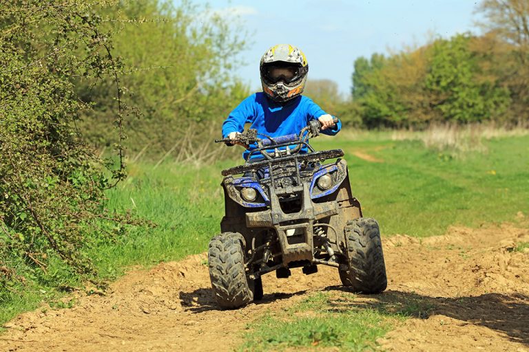 A teenage boy riding a quad bike in the countryside. (Adobe Stock │ #338368434 - dean)