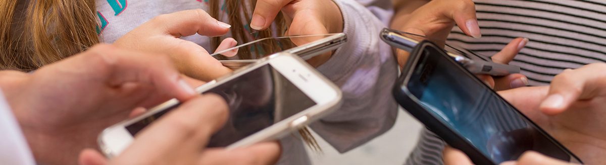 Group of young people with mobile phones on the street. (Adobe Stock │ #167337080 - carballo)