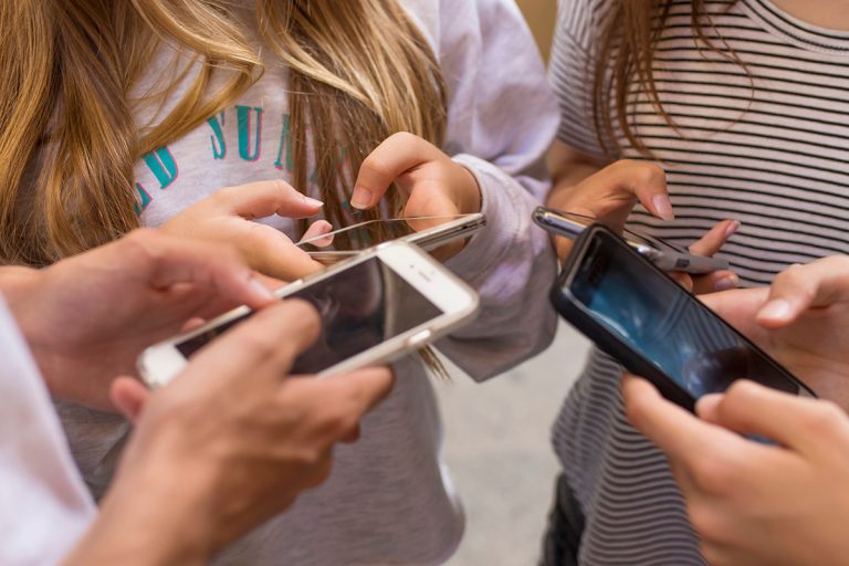 Group of young people with mobile phones on the street. (Adobe Stock │ #167337080 - carballo)