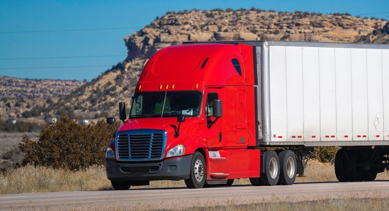 Eighteen wheel big rig tractor with trailer on highway. (Adobe Stock │ #336575444 - Michael Flippo)