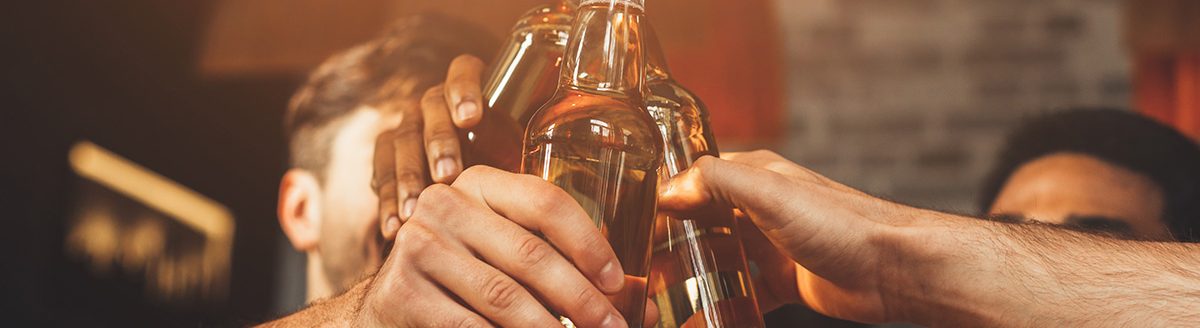 Men Drinking Beer And Clinking Bottles At Bar. (Adobe Stock │ #269059411 - Prostock-studio)