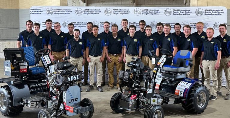 Members of the Jackrabbit Tractor Club assemble with their 2024, left, and 2025 entries at the International Quarter-Scale Tractor Student Design Competition at the Expo Gardens Fairgrounds in Peoria, Illinois. Entered in separate classes at this year’s competition, both placed second. (SDSU Extension)