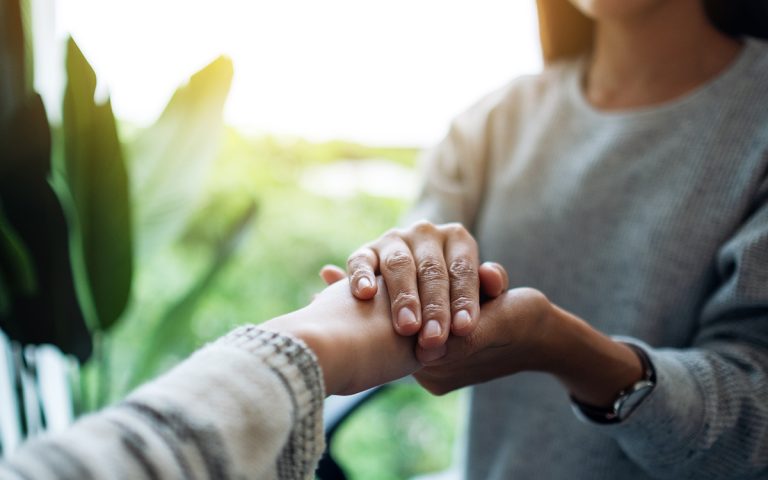 Women holding each other hands for comfort and sympathy. (Adobe Stock │ #381836691 - Farknot Architect)