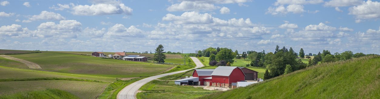 Farm with a red barn on a curving road in the Iowa countryside on a beautiful spring day. (iStock │ #2157489040 - Willard)