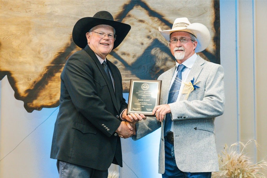 New Mexico State University Quay County Cooperative Extension Service Program Director Jason Lamb, left, accepted the distinguished service award from past NACAA President Scott Jensen at the National Association of County Agricultural Agents Annual Meeting and Professional Improvement Conference. (Courtesy photo)