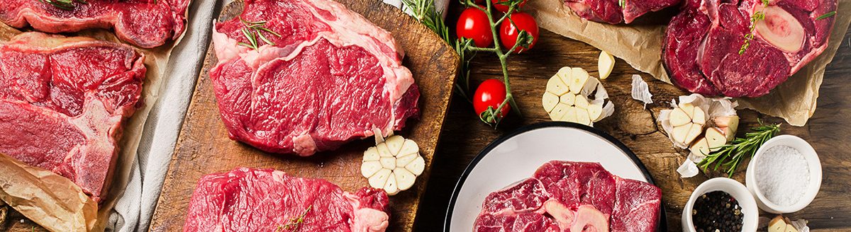 Raw beef meat on a dark wooden board. (Adobe Stock │ #166587845 - bit24)