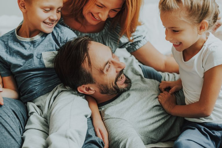 Happy parents and two kids having fun together. (Adobe Stock │ #245635985 - Yakobchuk Olena)