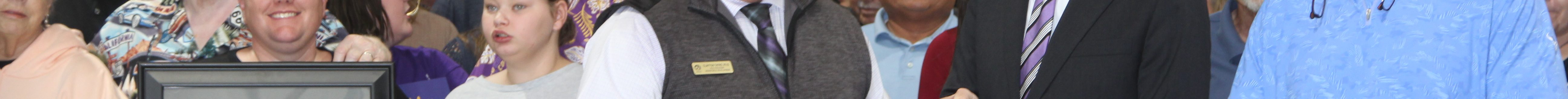 U.S. Sen. Jerry Moran cuts a ribbon with assistance from Clayton Tatro (immediately left) and Gary Harshberger (immediately right) and also included Audree Worth holding a photo of her late dad, Jeffrey Cole. (Journal photo by Dave Bergmeier.)