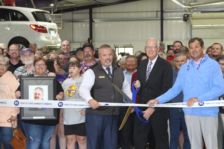 U.S. Sen. Jerry Moran cuts a ribbon with assistance from Clayton Tatro (immediately left) and Gary Harshberger (immediately right) and also included Audree Worth holding a photo of her late dad, Jeffrey Cole. (Journal photo by Dave Bergmeier.)