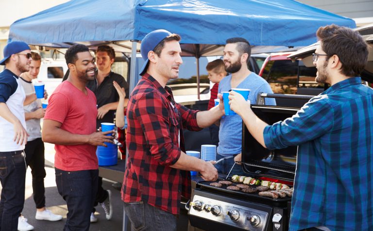Group of sports fans tailgating at a stadium. (iStock │ #502868546 - monkeybusinessimages)