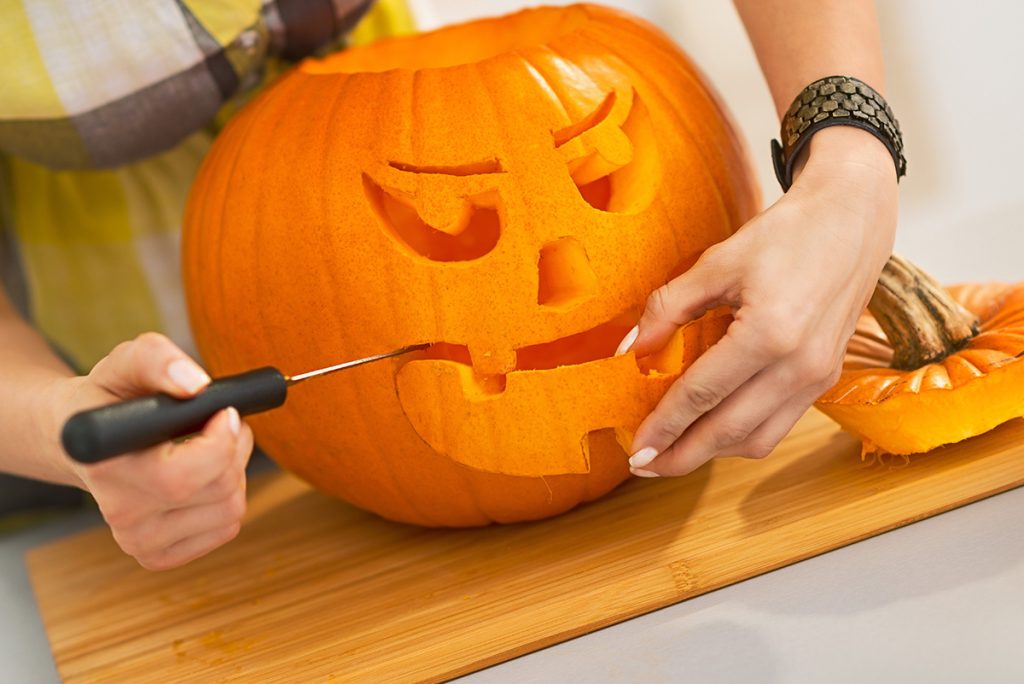 Carving a big orange pumpkin Jack-O-Lantern. (Adobe Stock │ #120948325 - Alliance)