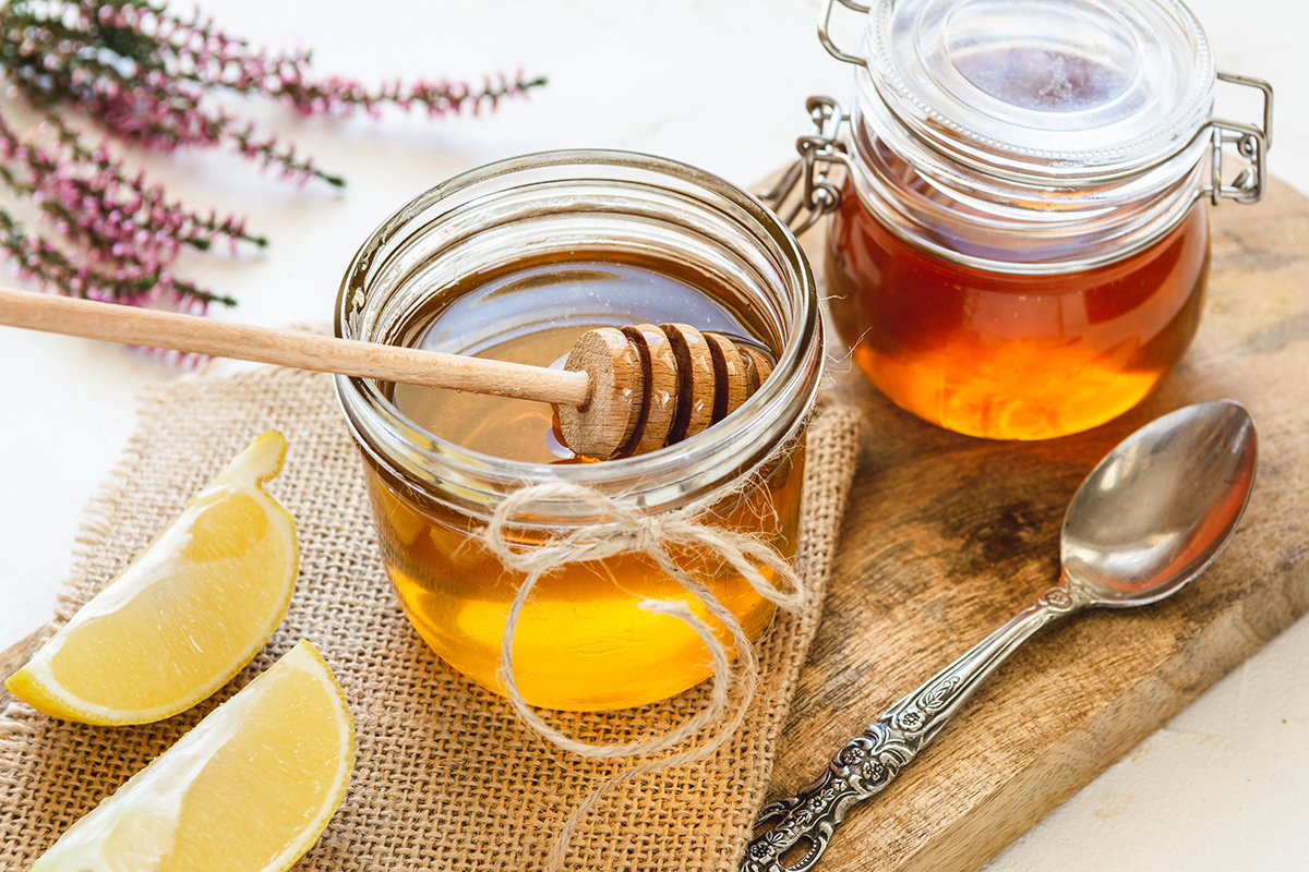 Honey in jar with fresh heather on wooden background. (Adobe Stock │ #231533123 - vivoo)