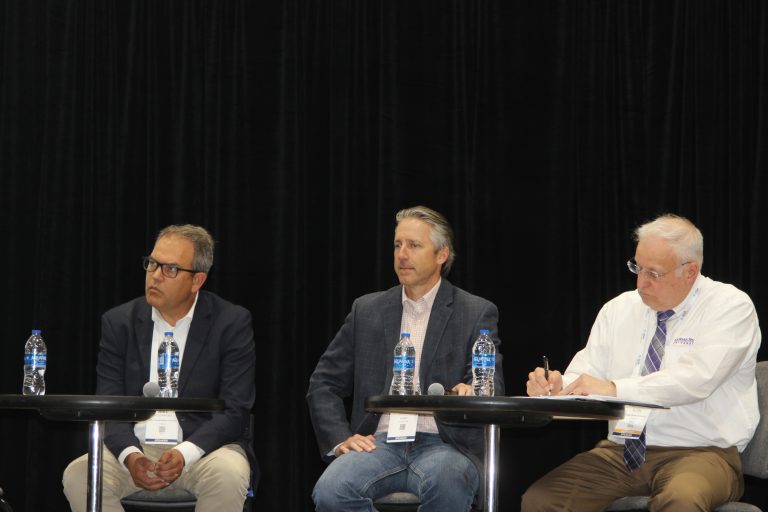(Not pictured) Moderator Ken Eriksen leads a discussion on grain storage, marketing and shipping with panelists (from left) Mike Steenhoek, Scott Sartor and Guy Allen. (Journal photo by Dave Bergmeier.)