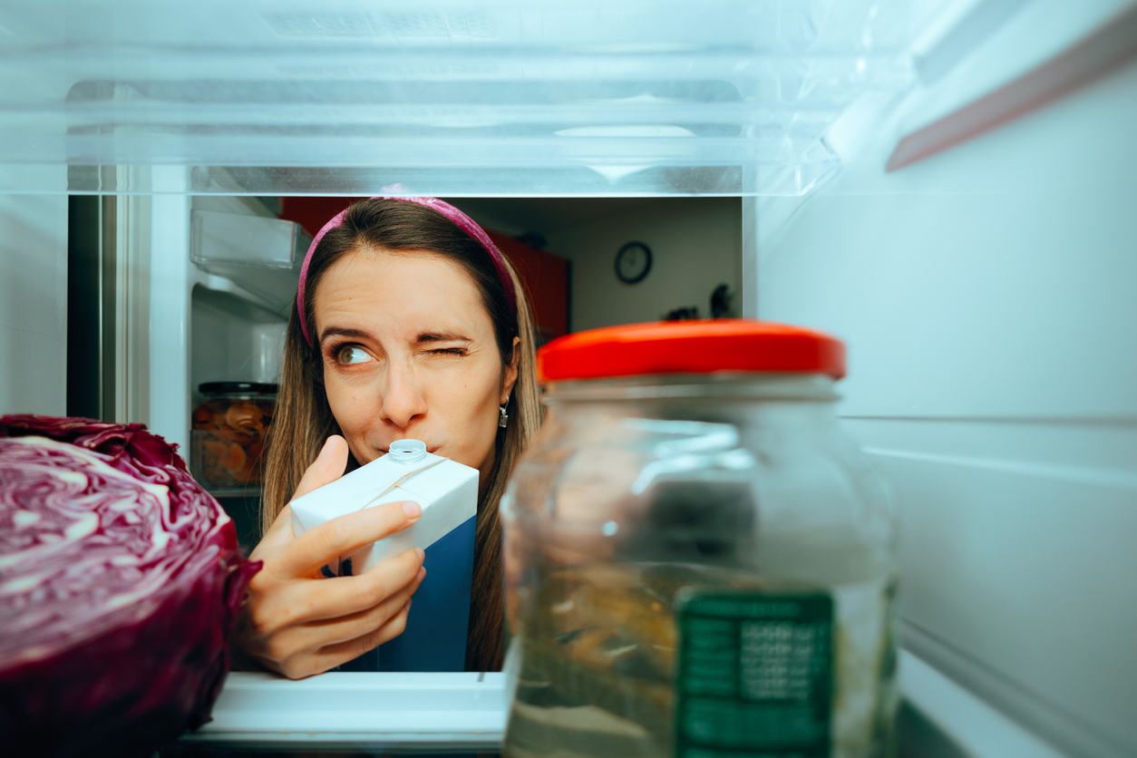 Cautious girl checking the smell of her diary product. (iStock │ #1838896474 - nicoletaionescu)