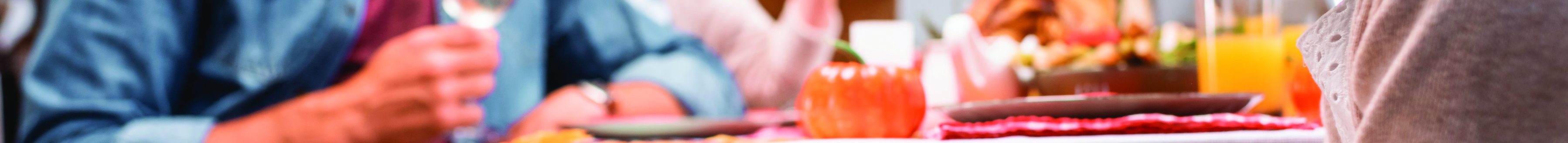 Selective focus of girl stroking golden retriever while family celebrating thanksgiving day. (Photo courtesy of Shutterstock │ #1823341958 - LightField Studios)