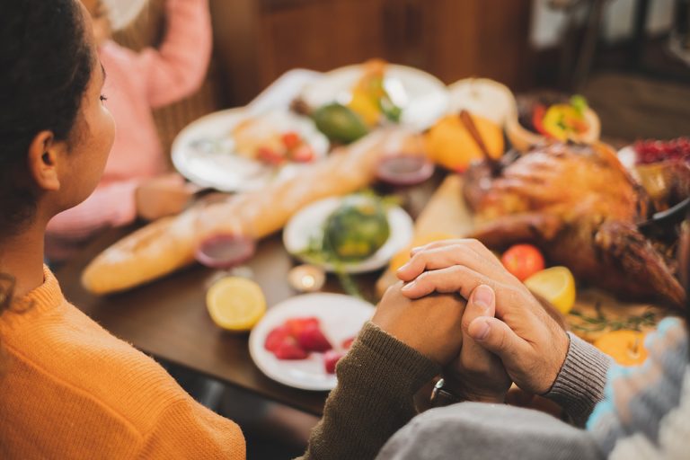 Happy Thanksgiving dinner at home, praying and blessing before having dinner. (Adobe Stock │ #294890305 - Nattakorn)