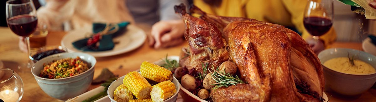 Close-up of Thanksgiving turkey during family dinner at dining table. (Adobe Stock │ #454595209 - Drazen)