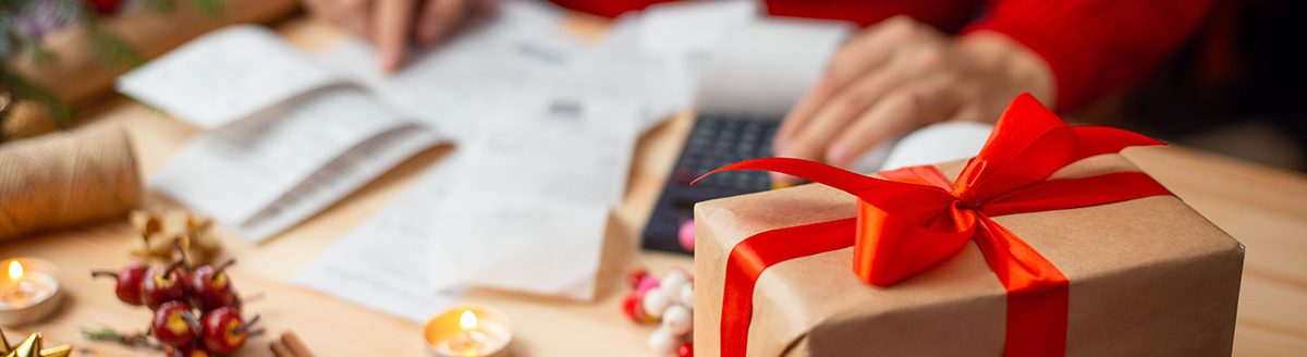 Table full of bills, hands of a woman, who checks and calculates everything. Christmas shopping concept. (Adobe Stock │ #539112708 - Vitalii)