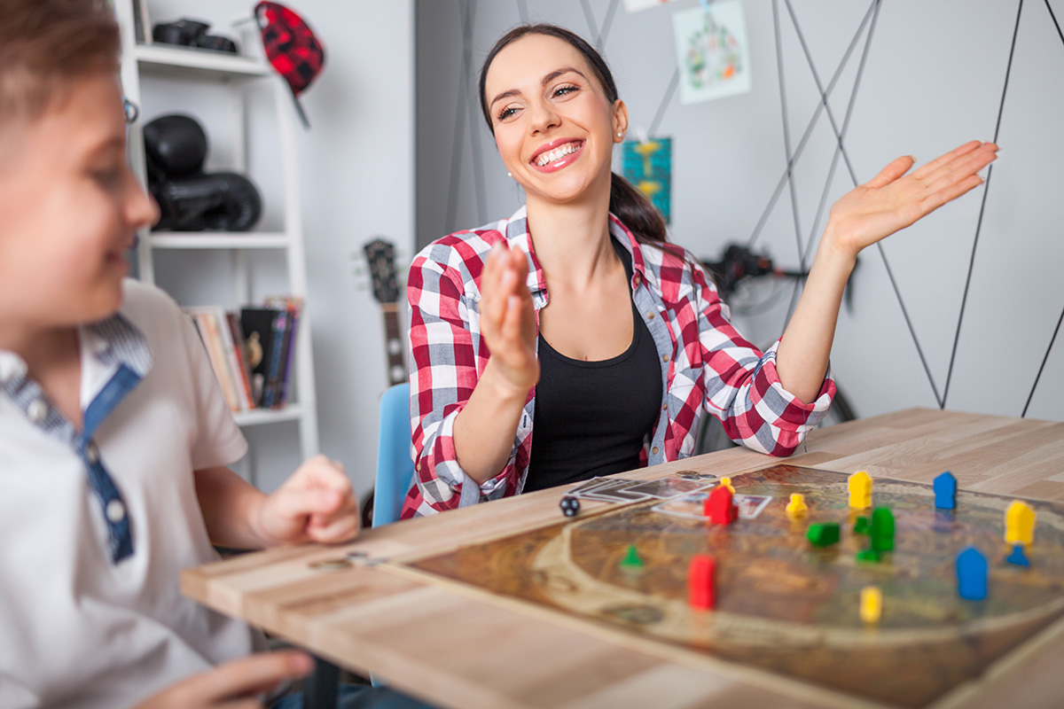 Mother and son playing modern board game. (Adobe Stock │ #207964263 - leszekglasner)
