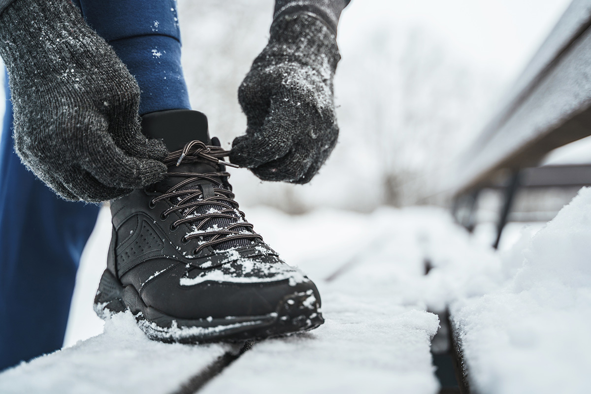 Jogger man is lacing his shoes during his winter workout. (Adobe Stock │ #464556101 - blackday)